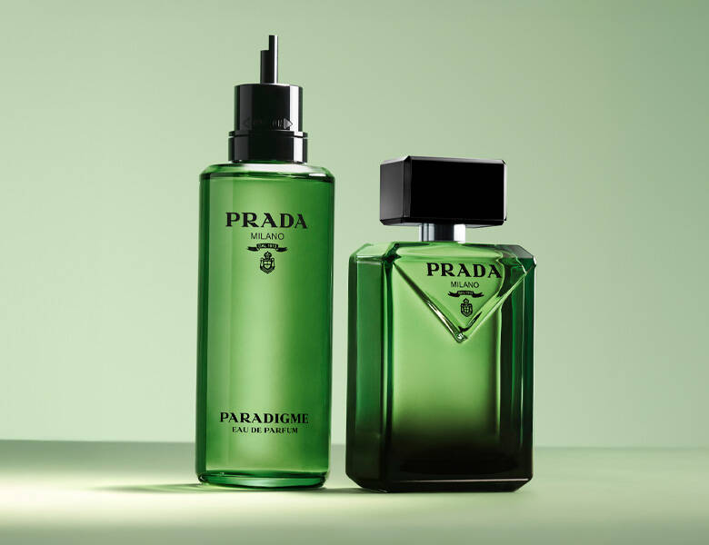 Her ses en lysergrøn baggrund med en grøn Prada parfume og dens refill version. 