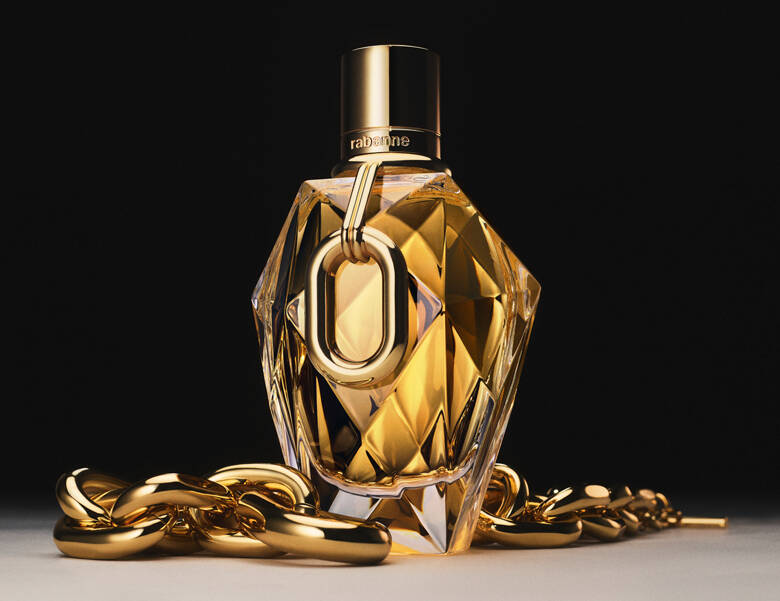 Her ses en sort baggrund med en stor Rabanne parfume i midten. Parfumen er guld og har guldkæder liggende rundt om sig. 