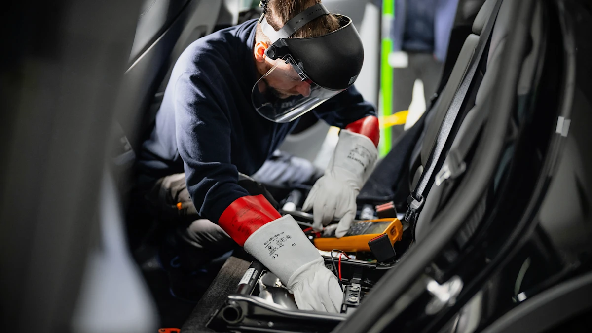Kfz-Techniker führt eine Hochvoltdiagnose an einem Elektrofahrzeug durch und arbeitet dabei mit vorgeschriebener Schutzausrüstung an elektrischen Komponenten.