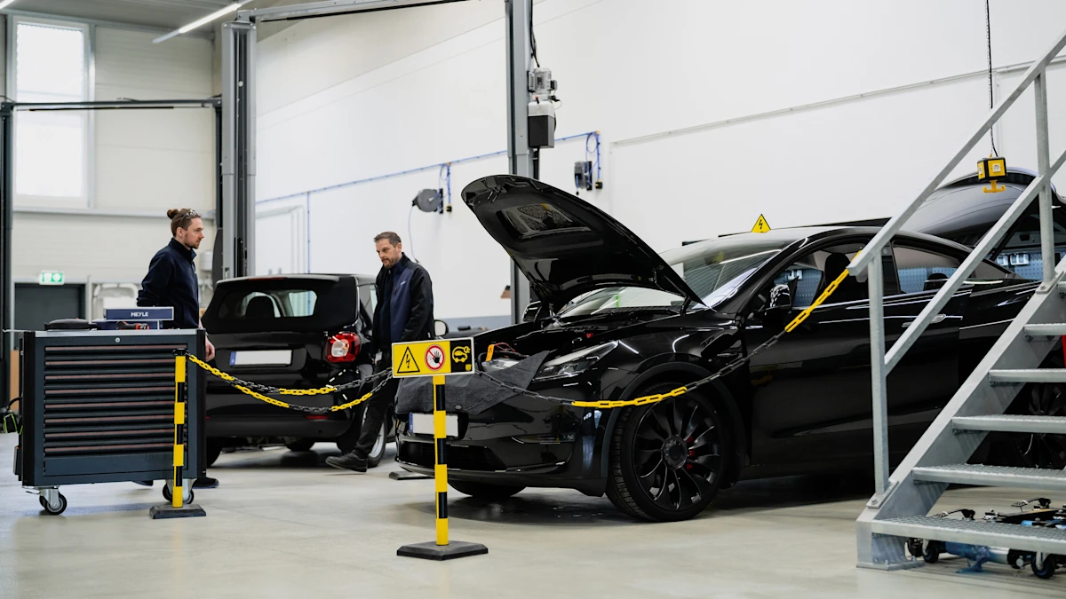 Kfz-Techniker bewertet den Zustand einer Hochvoltbatterie anhand von Diagnose- und Messdaten im Motorraum eines Elektrofahrzeugs unter Einhaltung der Hochvoltsicherheitsvorschriften.