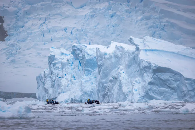 antarctica expeditions in zodiac near an iceberg