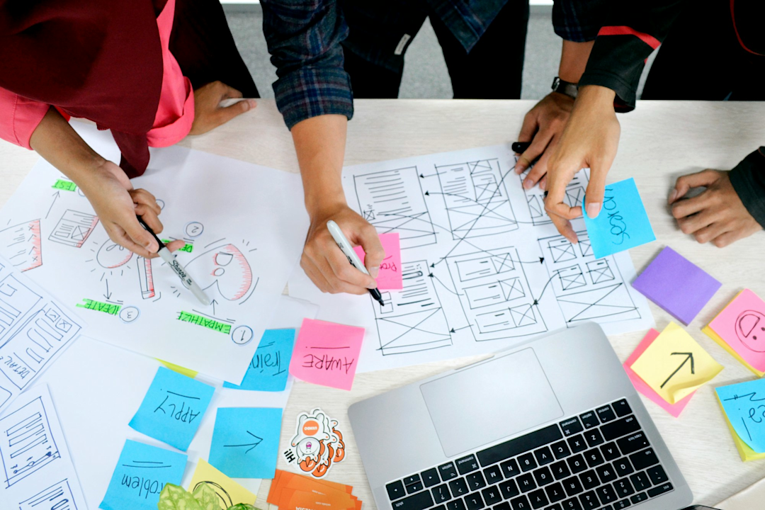 several hands working on paper prototypes