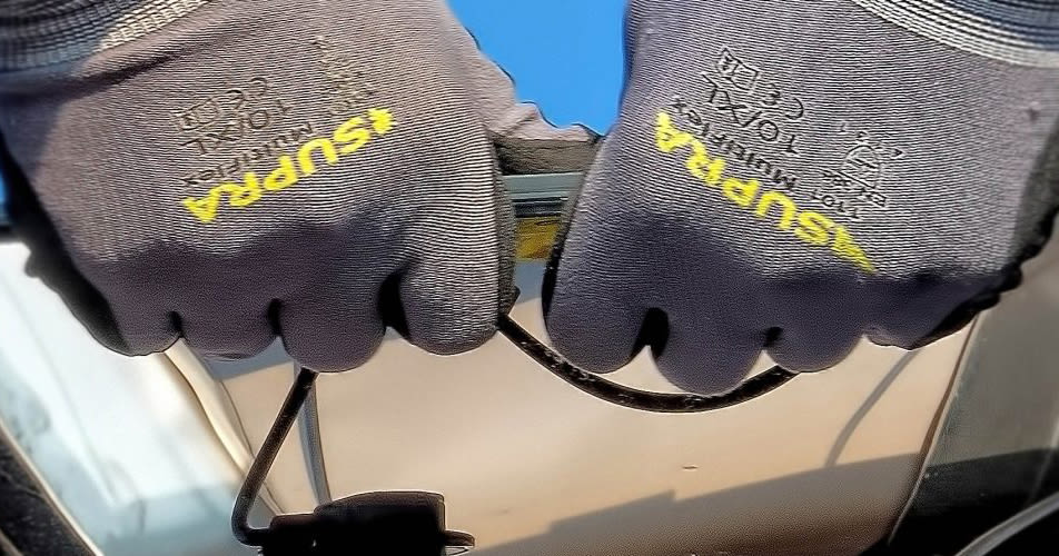 Detailshot van handen die een kabel van Solen aan het verwerken zijn