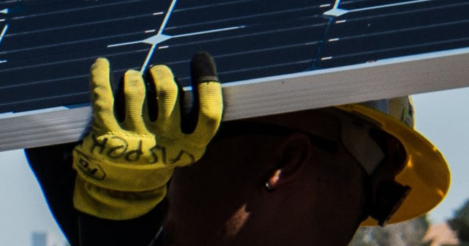 Een man houdt een zonnepaneel boven zijn hoofd