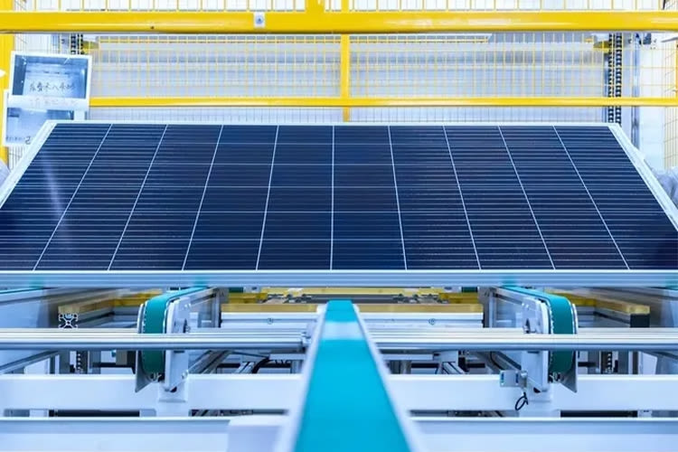 A large solar panel on an assembly line in a brightly lit factory. The setting conveys technological advancement and industrial efficiency.