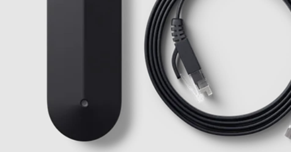 Een Tibber Pulse slimme meter aan de linkerkant en een opgerolde Ethernetkabel aan de rechterkant tegen een lichtgrijze achtergrond.