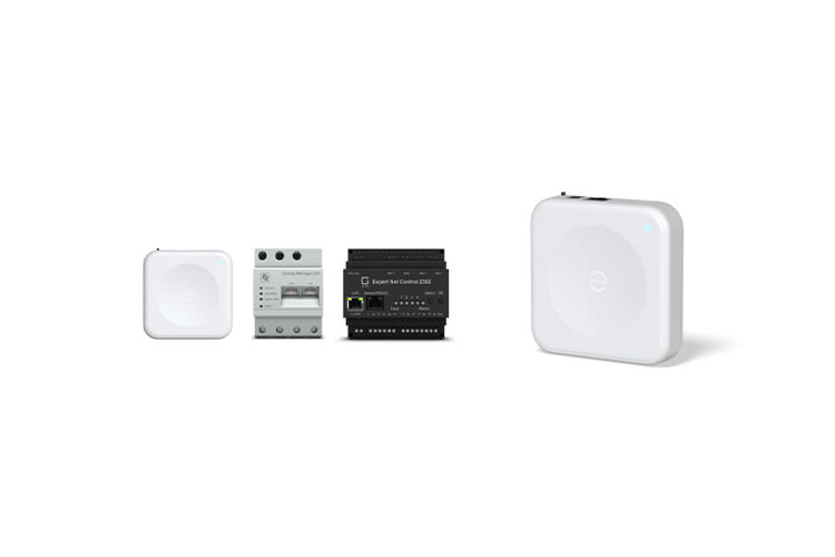 Four smart home devices including the Enphase IQ Energy Router are arranged side by side. They are sleek, rectangular, and feature buttons and ports, suggesting advanced technology.