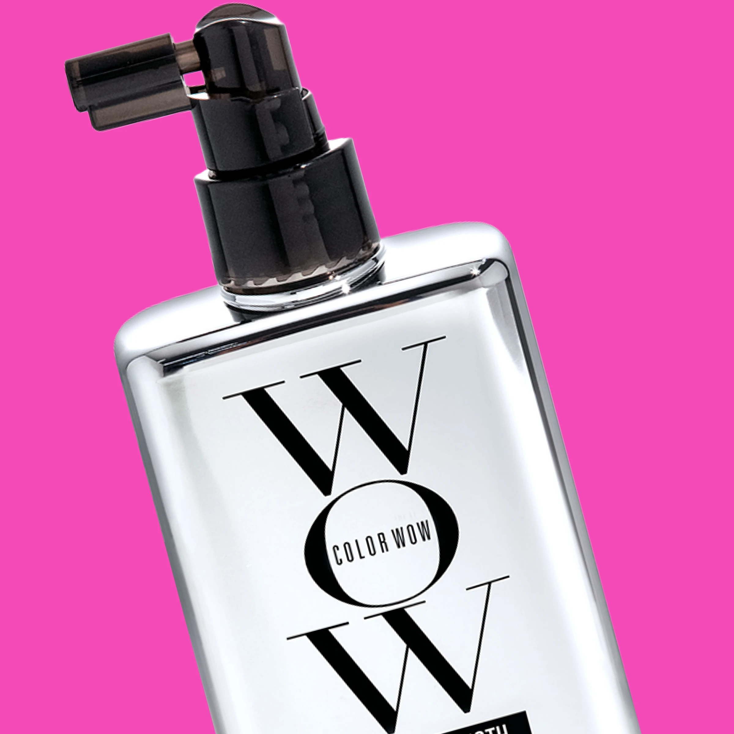 En sølvfarget Color Wow-flaske med svart pumpe og logo mot rosa bakgrunn.