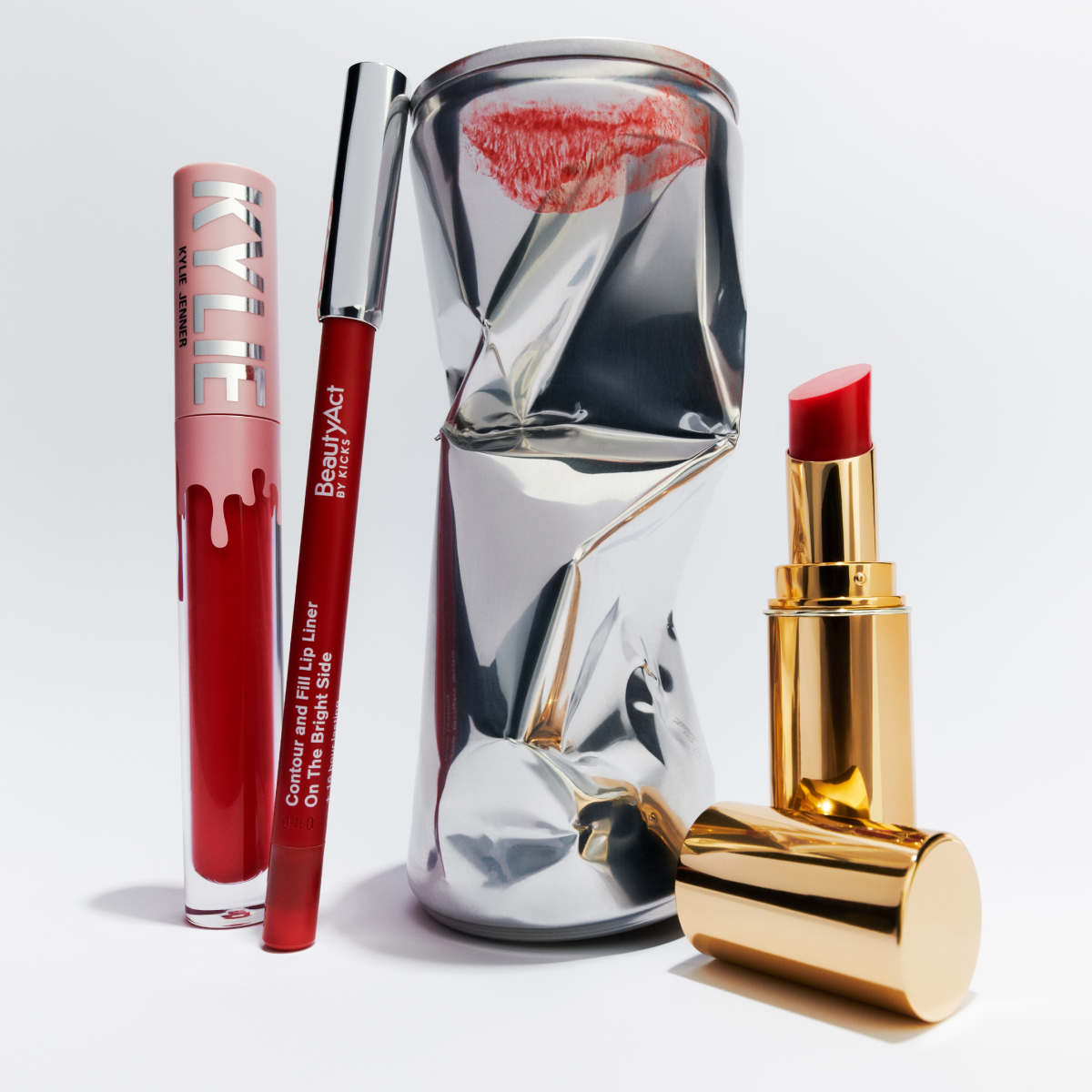 Röda läpprodukter inklusive läppstift, läppglans och läppenna, bredvid en krossad burk med ett läppavtryck.