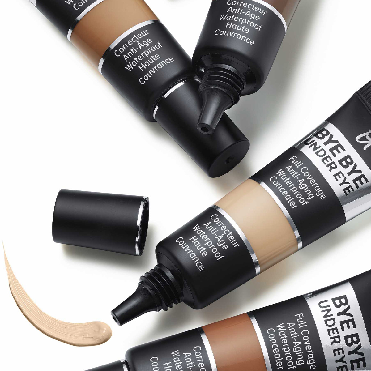 Fire concealere fra merket It Cosmetic i fire forskjellige nyanser mot en hvit bakgrunn.