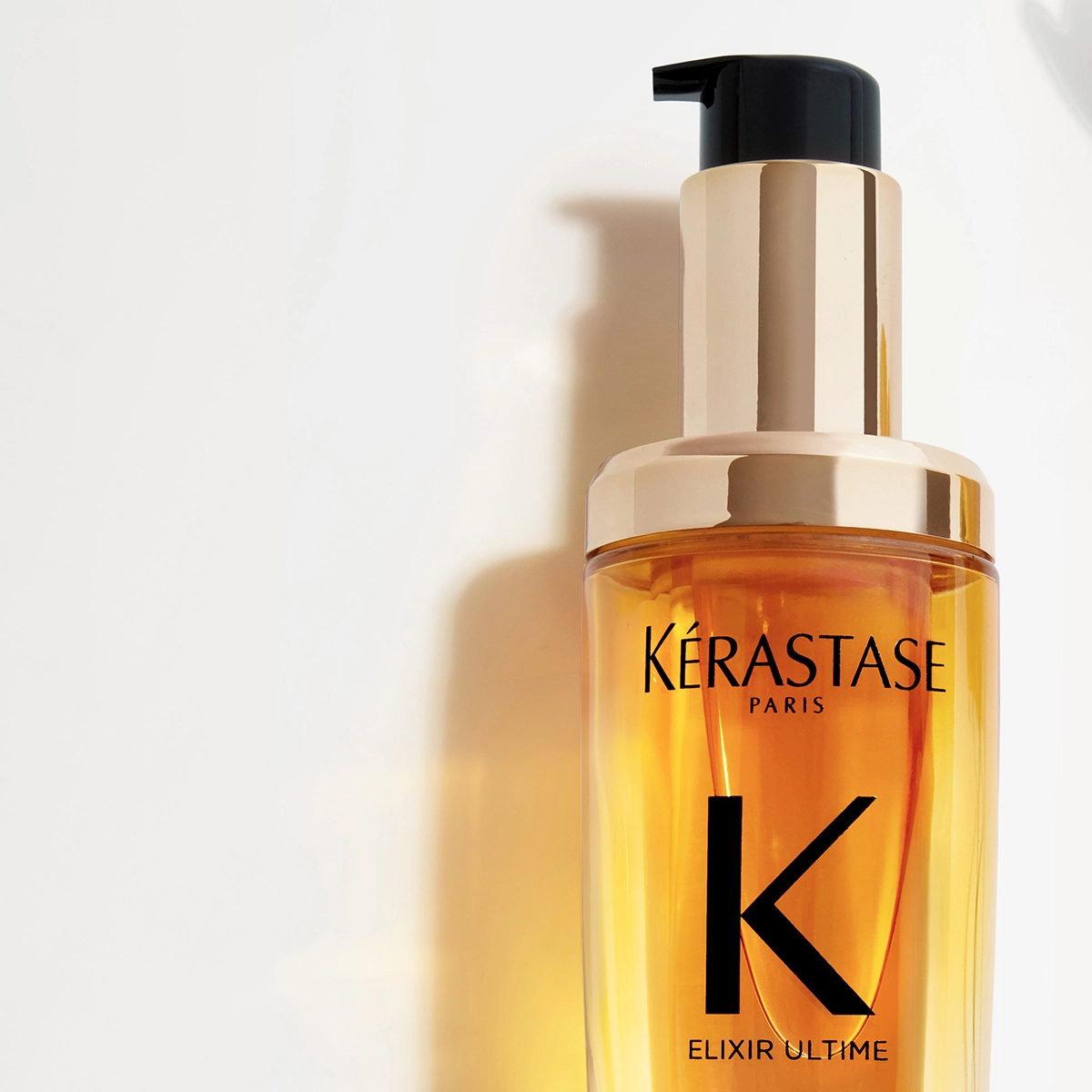 Kérastase Elixir Ultime hiusöljypullo, jossa on musta pumppu ja kultaiset yksityiskohdat.