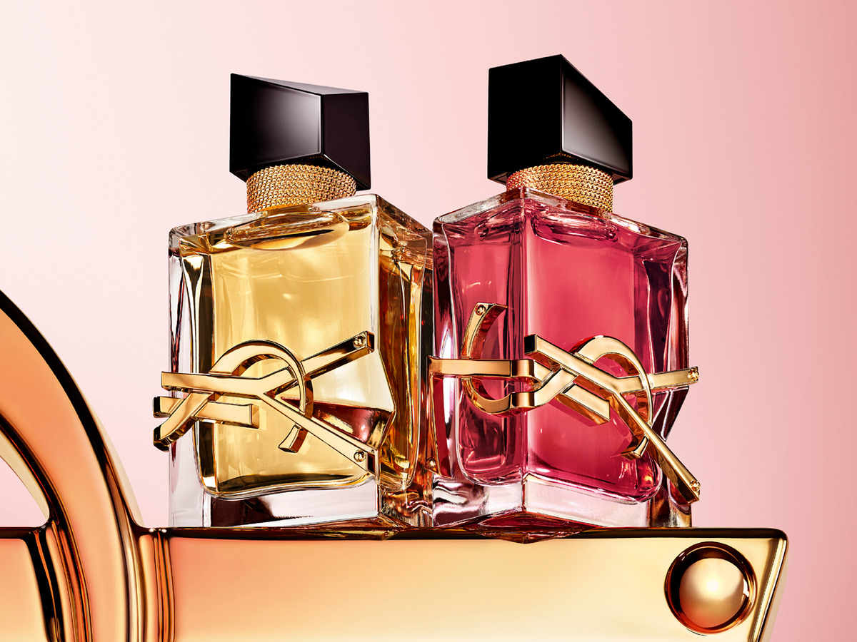 Två lyxiga parfymflaskor, guld och rosa, med texten NEW!