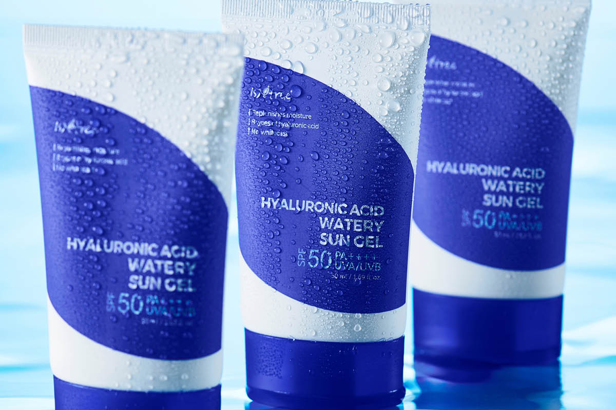 Tre tuber med solkremen Isntree HYALURONIC ACID WATERY SUN GEL med teksten “SPF 50+ PA++++ UVA/UVB” og “50 ml / 1.69 fl. oz”. Tubene er dekket av vanndråper mot blå bakgrunn.