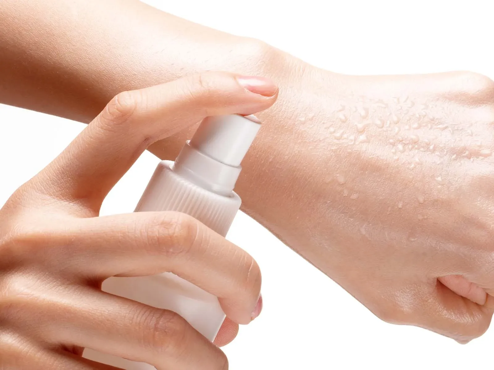 En hånd som sprayer væske på en annen hånd.