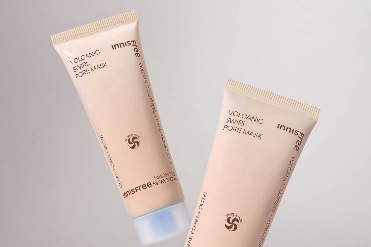 Kaksi beigeä tuubia Innisfree VOLCANIC SWIRL PORE MASK -kasvonaamiota vaaleaa taustaa vasten. Pakkauksessa näkyy tekstit “Innisfree”, “VOLCANIC CLUSTERS + HYALURONIC ACID”, “CLEAR PORES + GLOW”, “SQUEEZE HERE” ja “Pads Net 110g Net Wt. 3.88oz”.