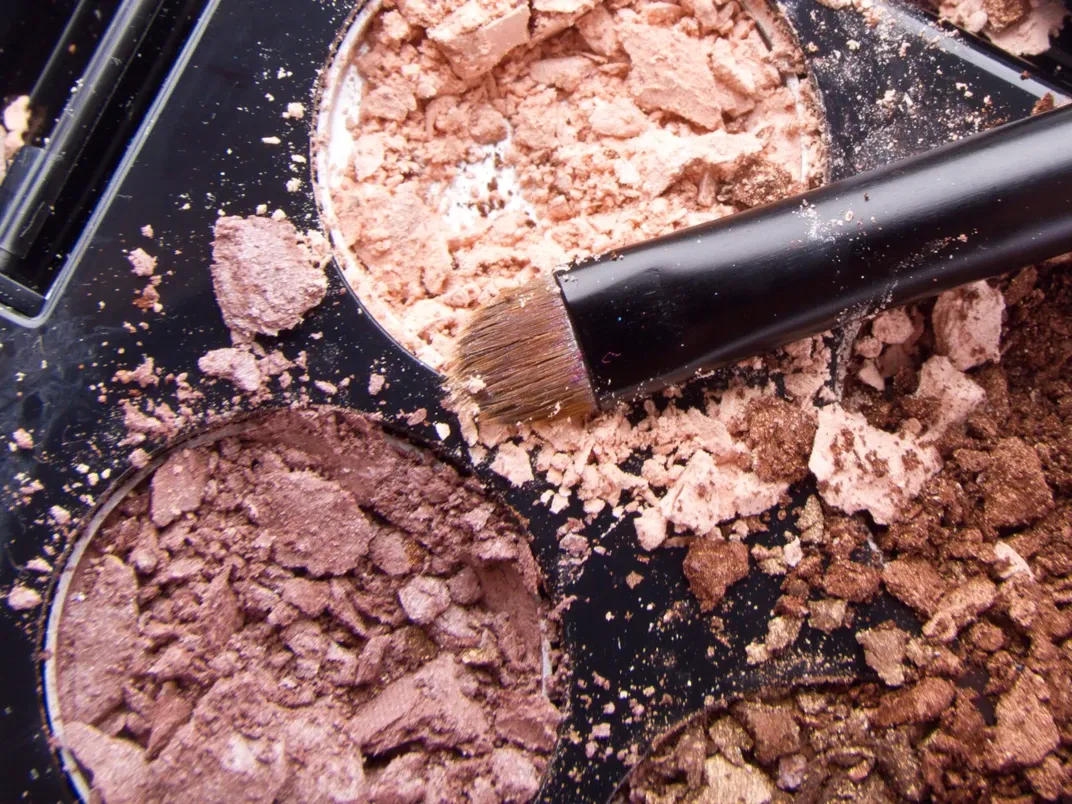 Øyenskyggepalett med sminkebørste.