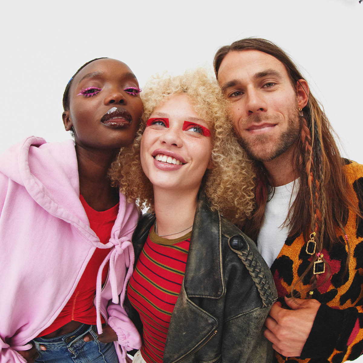 to kvinner og en mann som strår tett sammen