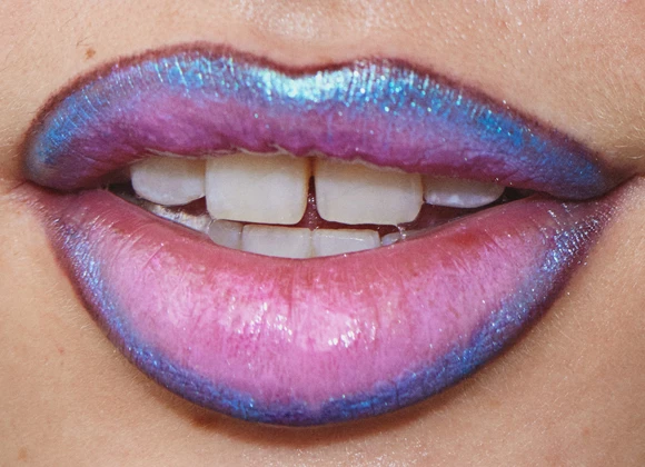 Lähikuva huulista, jotka on maalattu vaaleanpunaisen ja sinisen eri sävyillä.