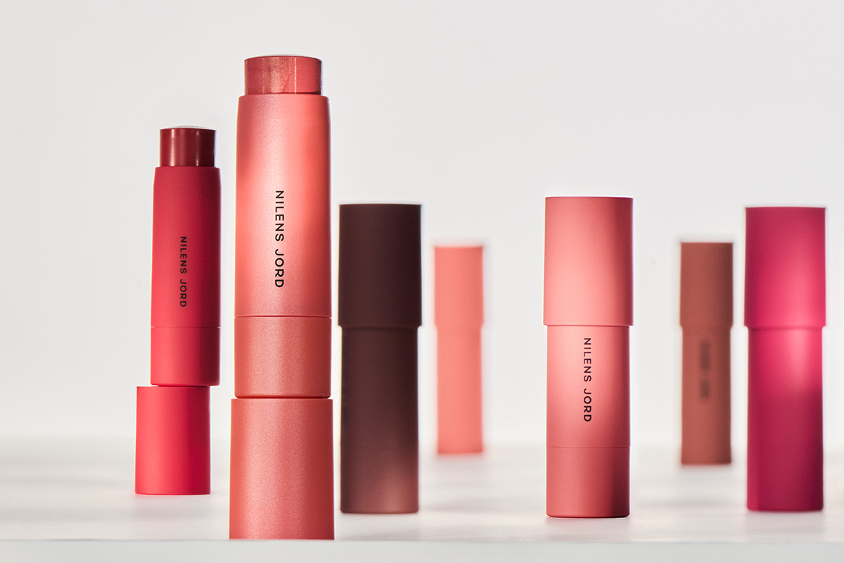 To personer sitter ved siden av hverandre. Begge er kledd i lyse klær og har lys hud.