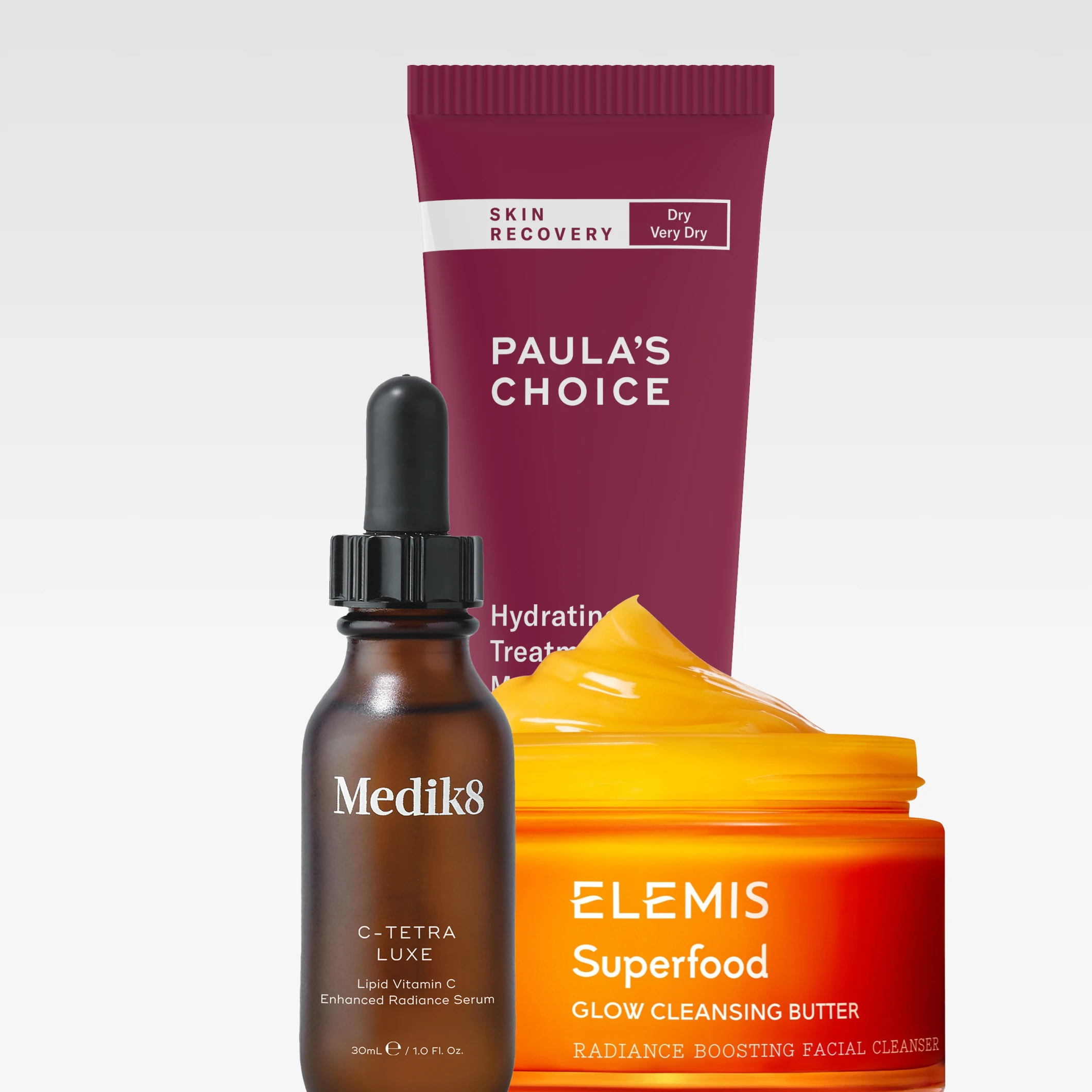 Hudvårdsprodukter från Medik8 “C-Tetra Luxe”, ELEMIS “Superfood Glow Cleansing Butter” och Paula’s Choice “Skin Recovery Hydrating Treatment Mask Dry Very Dry” visas med synliga produktnamn.