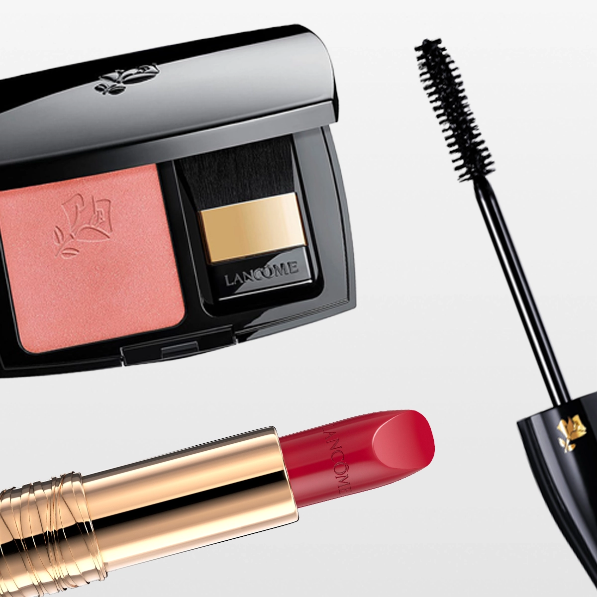 Lancôme-meikkiä: vaaleanpunainen poskipuna mustassa rasiassa peilillä ja siveltimellä, punainen huulipuna kullanvärisessä hylsyssä sekä ripsiväri harjalla. Lancôme-brändin nimi näkyy meikkituotteiden pakkauksissa: poskipuna, huulipuna ja mascara.