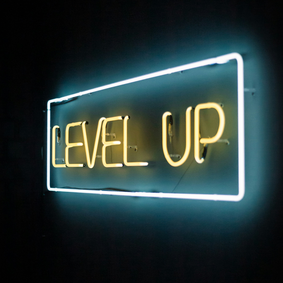 neonskilt med teksten «LEVEL UP» i gult og med en blå ramme rundt