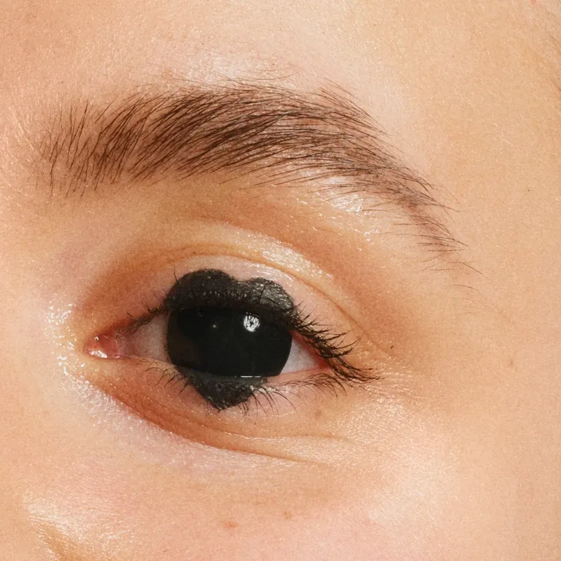 Øye med svart makeupdesign som er formet som et hjerte når det er koblet på svart iris.