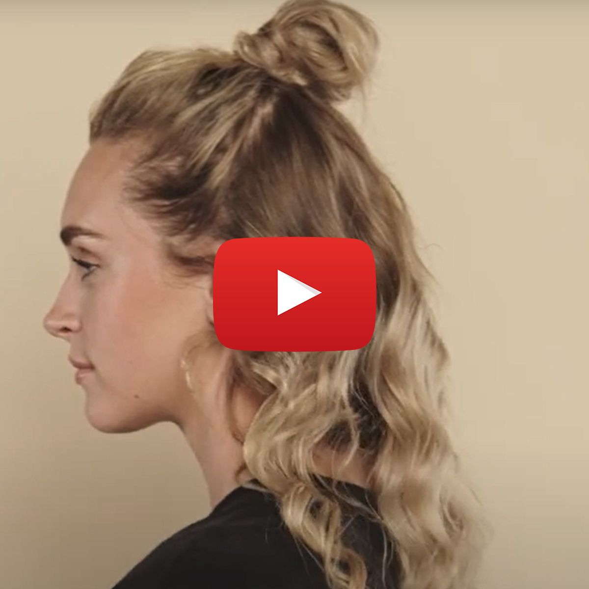 Tjej från sidan visar "Half messy bun" mot beige bakgrund.