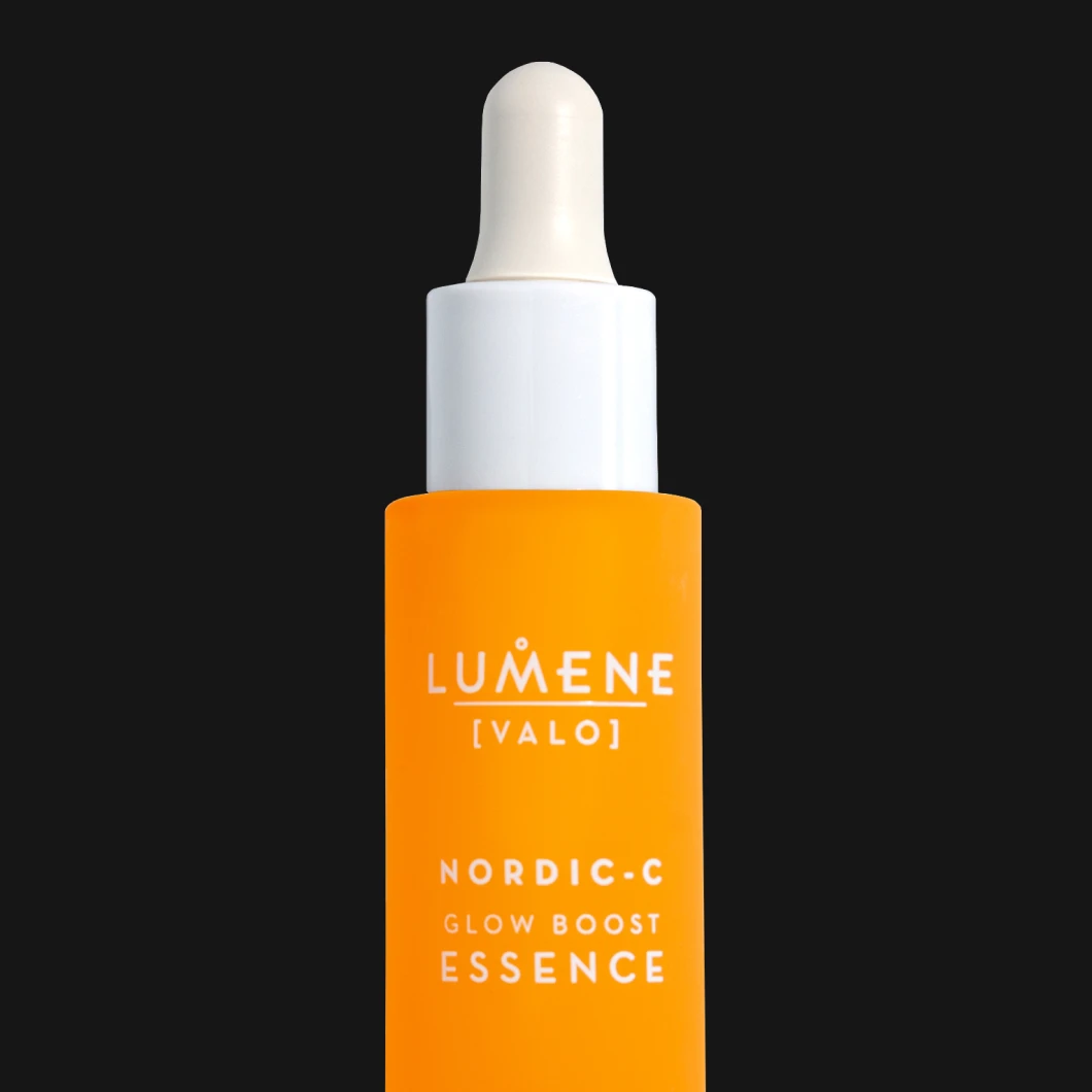 Orange glasflaska med pipett från Lumene Valo Nordic-C Glow Boost Essence mot svart bakgrund. Vit pipett och vit kork. Texten ”KICKS CLUB” samt ”−25% Member DEAL” visas i vitt och rosa.