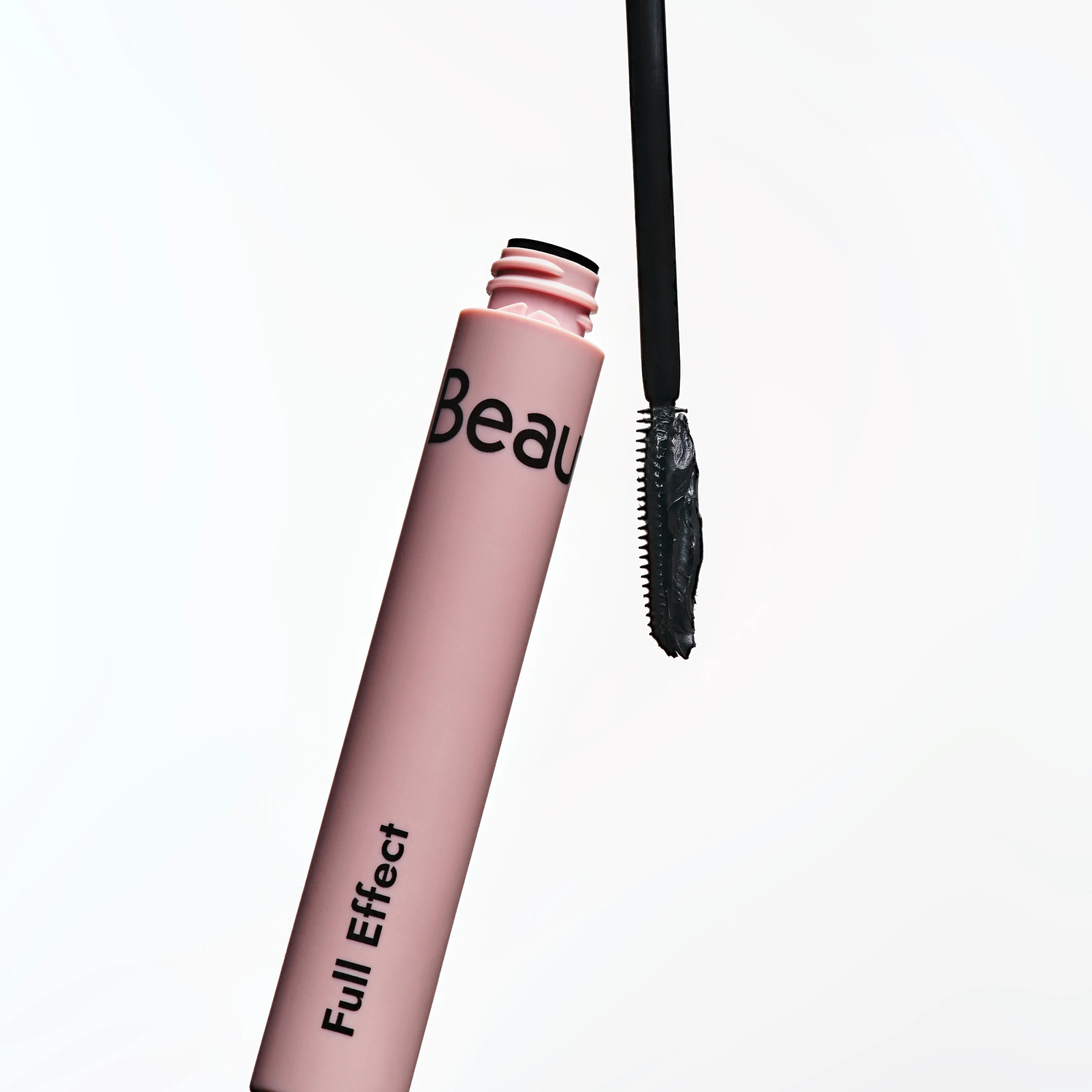Produktbild av BeautyAct mascara ”Full Effect” i rosa hylsa med avskruvad borste och synlig mascaraformel mot vit bakgrund.