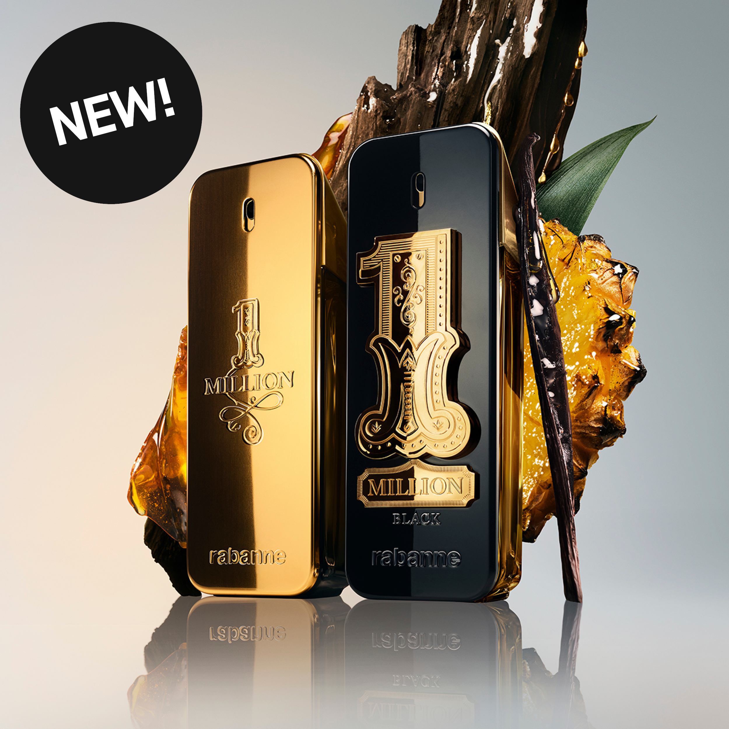 To Rabanne-parfymer, 1 Million og 1 Million Black, står foran vaniljestenger, ravfargede detaljer og grønne blader. Flaskene har tekstene "1 MILLION", "1 MILLION BLACK" og "rabanne", og en svart sirkel med teksten "NEW!" vises øverst til venstre.