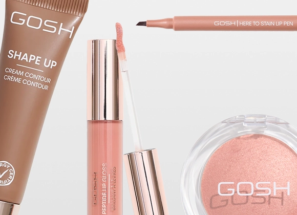 Närbild på sminkprodukter från GOSH: Shape Up Cream Contour Crème Contour med Allergy Certified-symbol, Here To Stain Lip Pen, Peptide Lip Gloss Brilliant Lip Glaze med applikator samt ett runt puderrouge med GOSH-logotyp. Produkterna visas i nude- och rosatoner mot ljus bakgrund.