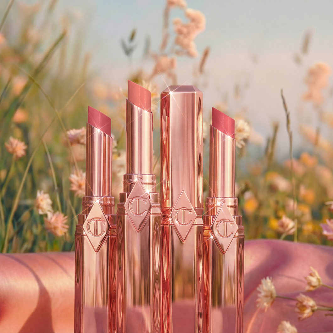 Charlotte Tilbury leppestifter i blomstereng, med teksten “Nyhet”.