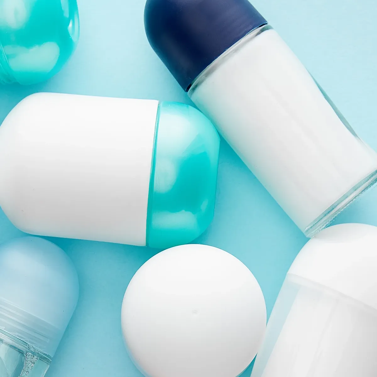 Kokoelma deodorantteja ja antiperspirantteja vaaleansinisellä taustalla.