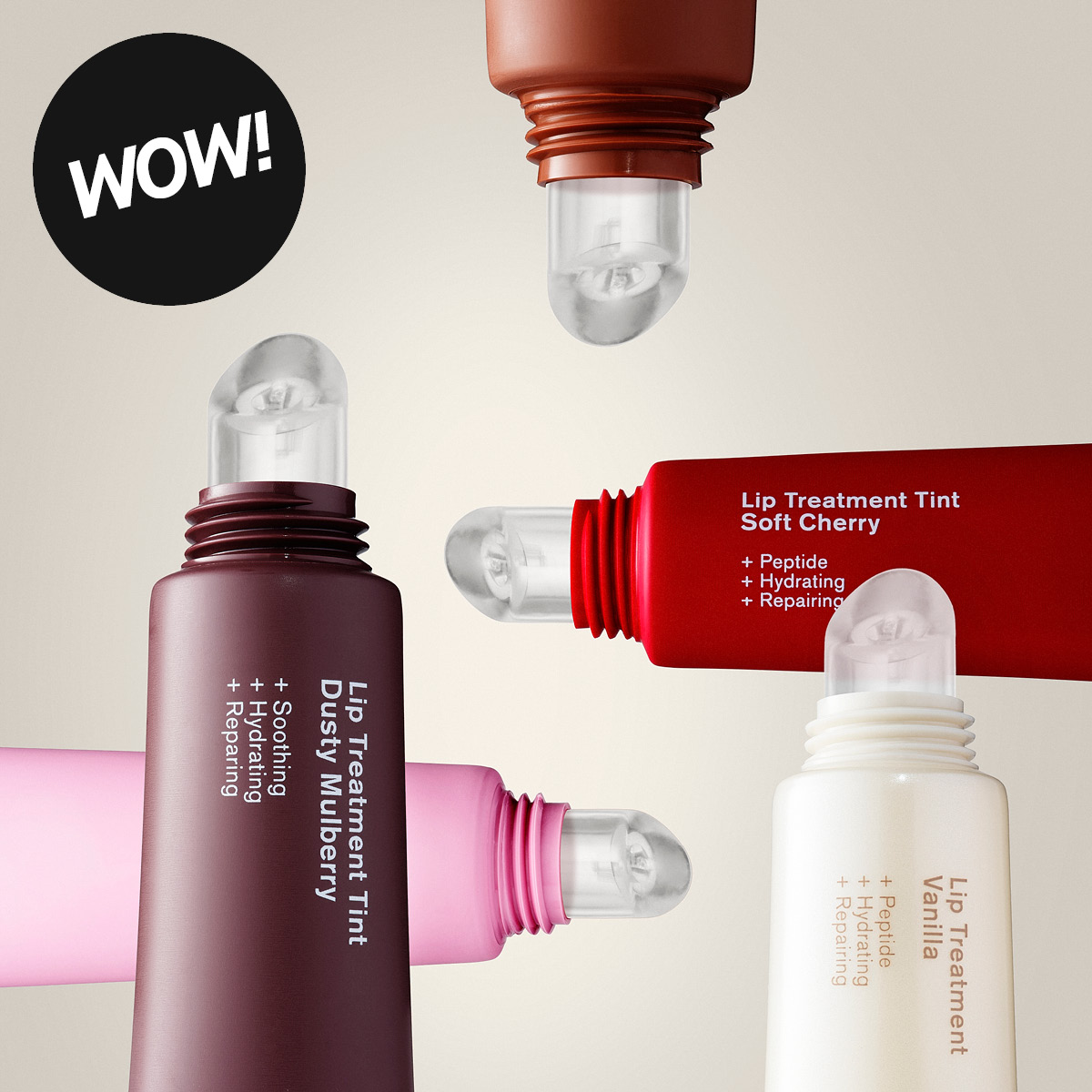 Fyra läppvårdsprodukter med metallapplikator visas mot en ljus bakgrund. En svart cirkel med texten "WOW!" syns, och förpackningarna har texterna "Lip Treatment Tint Dusty Mulberry", "Lip Treatment Tint Soft Cherry", "Lip Treatment Vanilla", "+ Peptide", "+ Hydrating" och "+ Repairing".