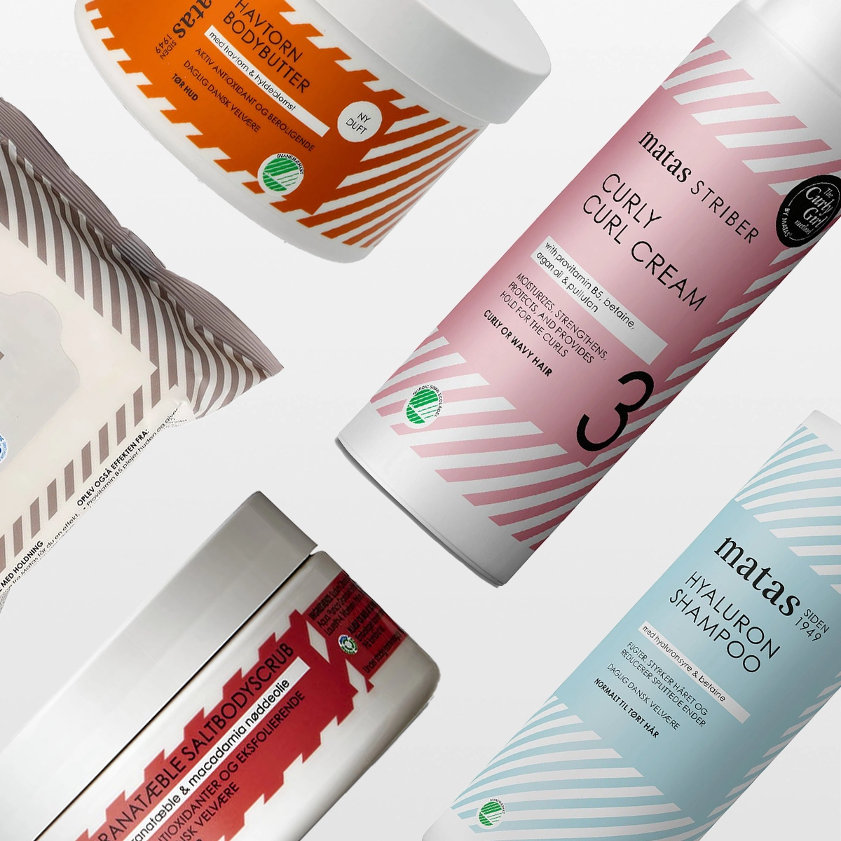 Erilaisten kauneustuotteiden kokoelma, joka sisältää bodybutterin, curl cream -voiteen, hyaluronisampoon, suolakuorinnan ja kasvopyyhkeitä. Tuotteet on tyylikkäästi aseteltu valkoista taustaa vasten