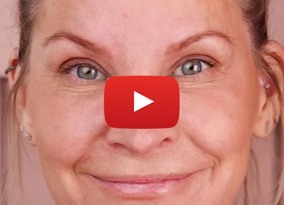 Lähikuva henkilöstä, joka katsoo hymyillen kameraan YouTube-soittopainikkeella.