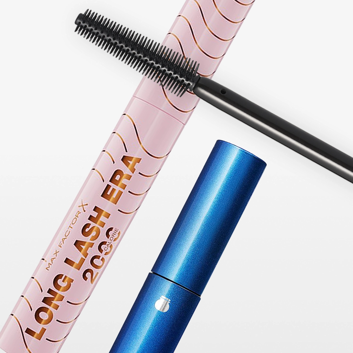 Närbild av rosa Max Factor X Long Lash Era 2000 Calorie mascara och blå Sensai mascara mot vit bakgrund, med en svart mascaraborste placerad över produkterna.