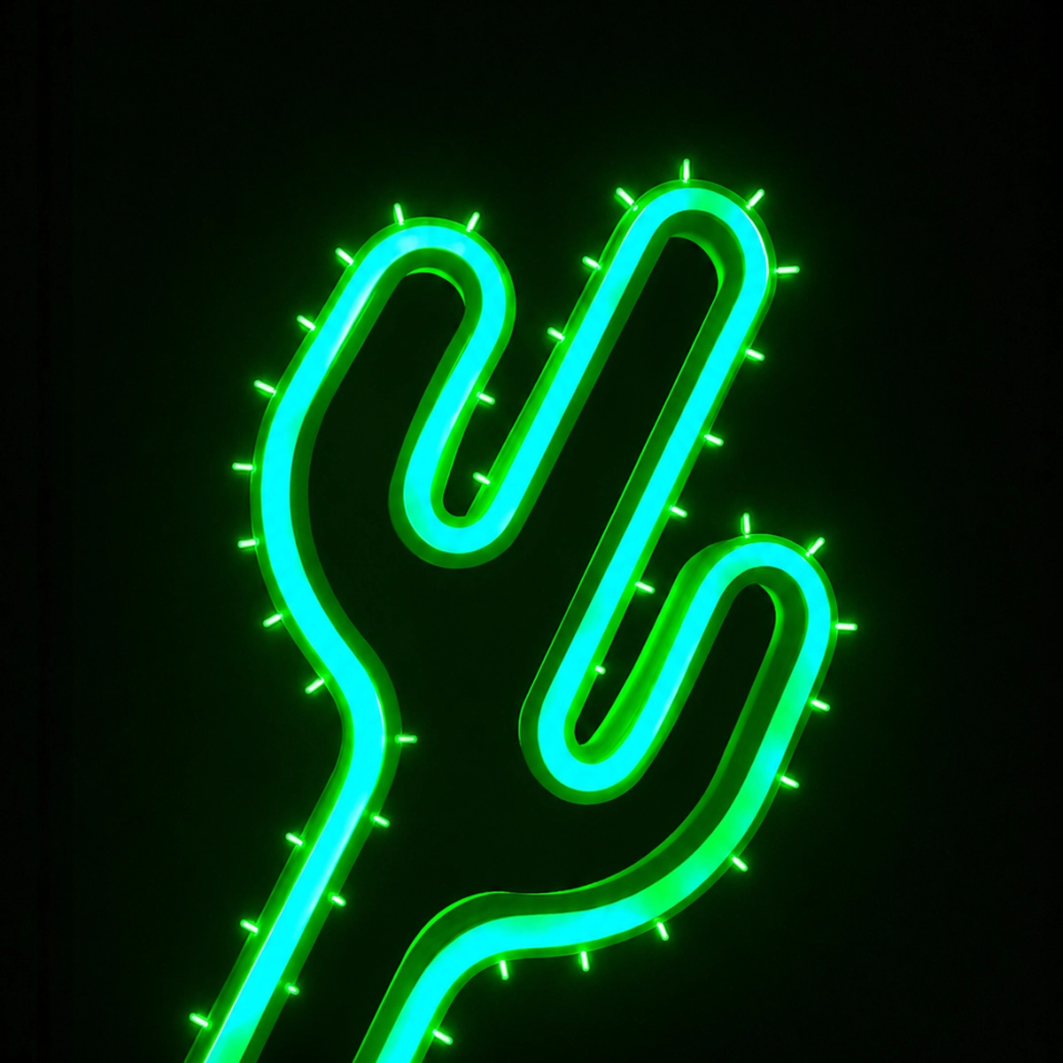 Neonskylt formad som en grön kaktus med turkosa detaljer mot svart bakgrund. Den lysande dekorationen har små upplysta taggar längs kanterna och skapar en modern och grafisk känsla.