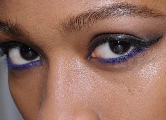 Nærbilde av en kvinnes øyne, sminket med svart eyeliner og blå kajal.
