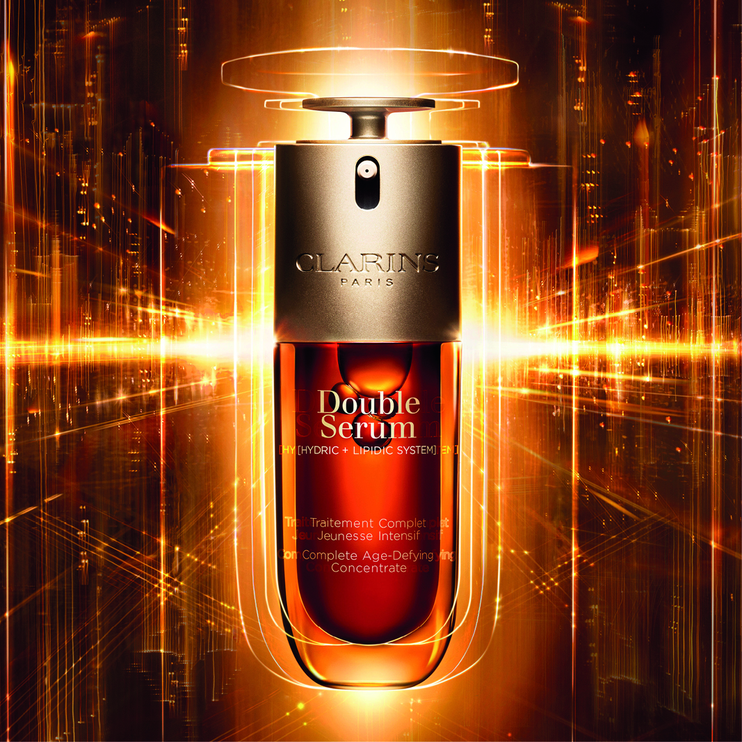 Clarins Double Serum-flaske med en glødende, gyllen bakgrunn. Flasken har et elegant design med teksten «Double Serum» og «Hydric + Lipidic System».
