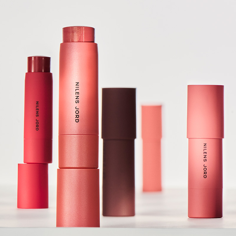 Nilens Jord läppstift i olika nyanser. Flera tuber i rött, rosa och brunt, med svart text.