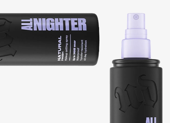 Urban Decay All Nighter makeup setting spray i svart flaske med lilla sprayhode, én liggende og én stående. Synlig tekst: “ALL NIGHTER”, “NATURAL finish”, “Waterproof”, “Up to 16h wear”, “Makeup setting spray” og “All day hydration”.