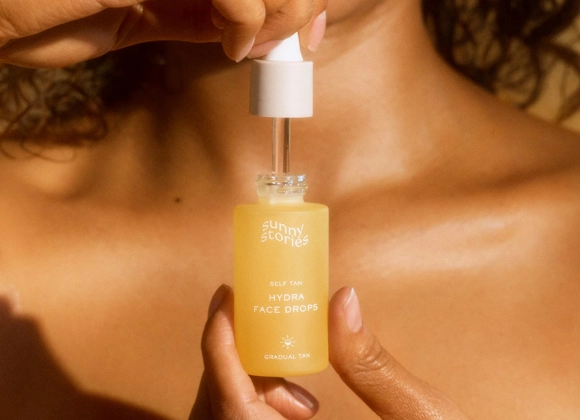 Henkilö pitää kädessään Sunny Stories Hydra Face Drops -pulloa.