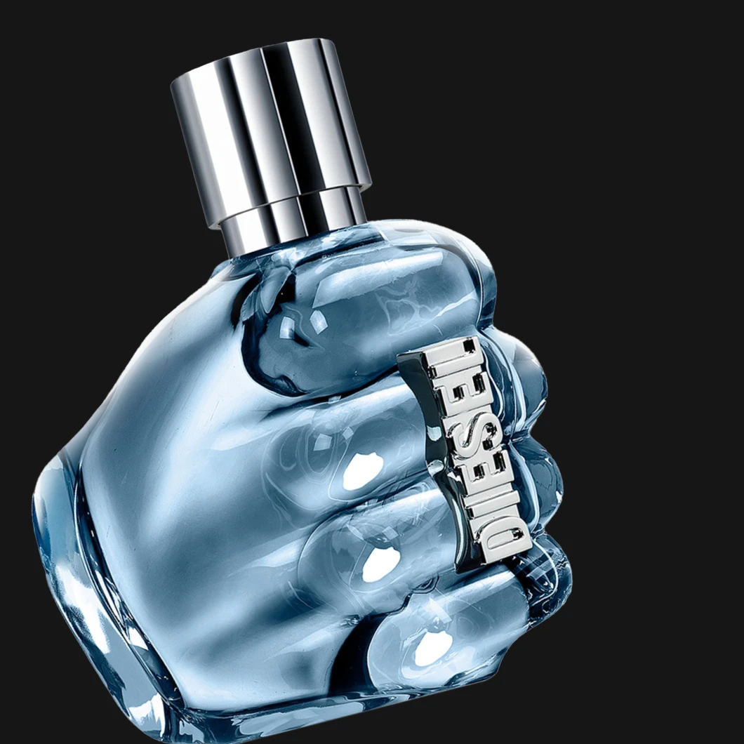 Diesel-hajuvesi sinisessä lasipullossa, joka on muotoiltu nyrkin muotoon ja koristeltu metallisella ”Diesel”-tekstillä, mustalla taustalla.