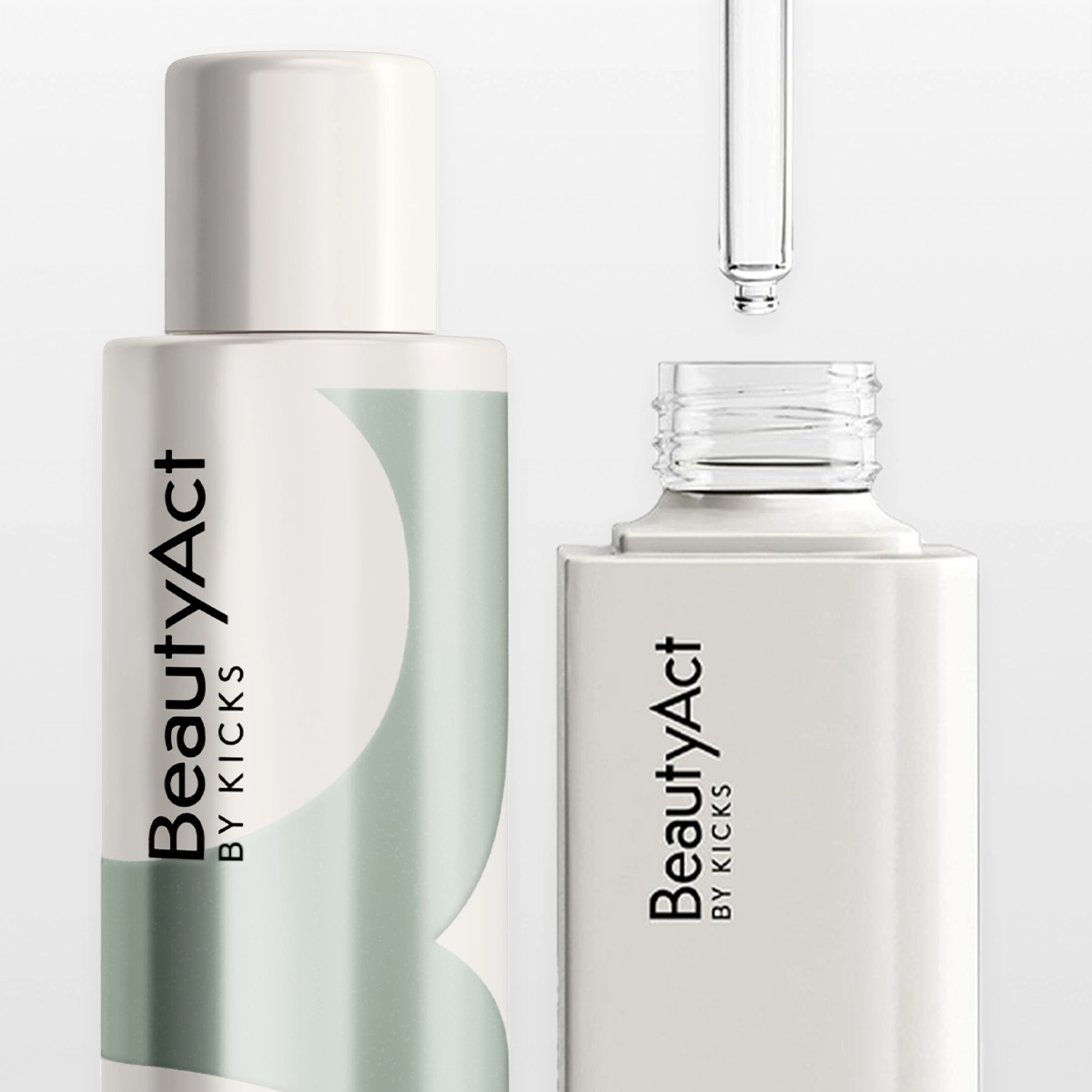 Kaksi BeautyAct By KICKS -ihonhoitotuotetta lähikuvassa vaaleanharmaata taustaa vasten sekä läpinäkyvä pipetti avoimen seerumipullon yläpuolella. Teksti “BeautyAct By KICKS” näkyy selkeästi molemmissa tuotteissa modernissa ja pelkistetyssä ihonhoitopakkauksessa.