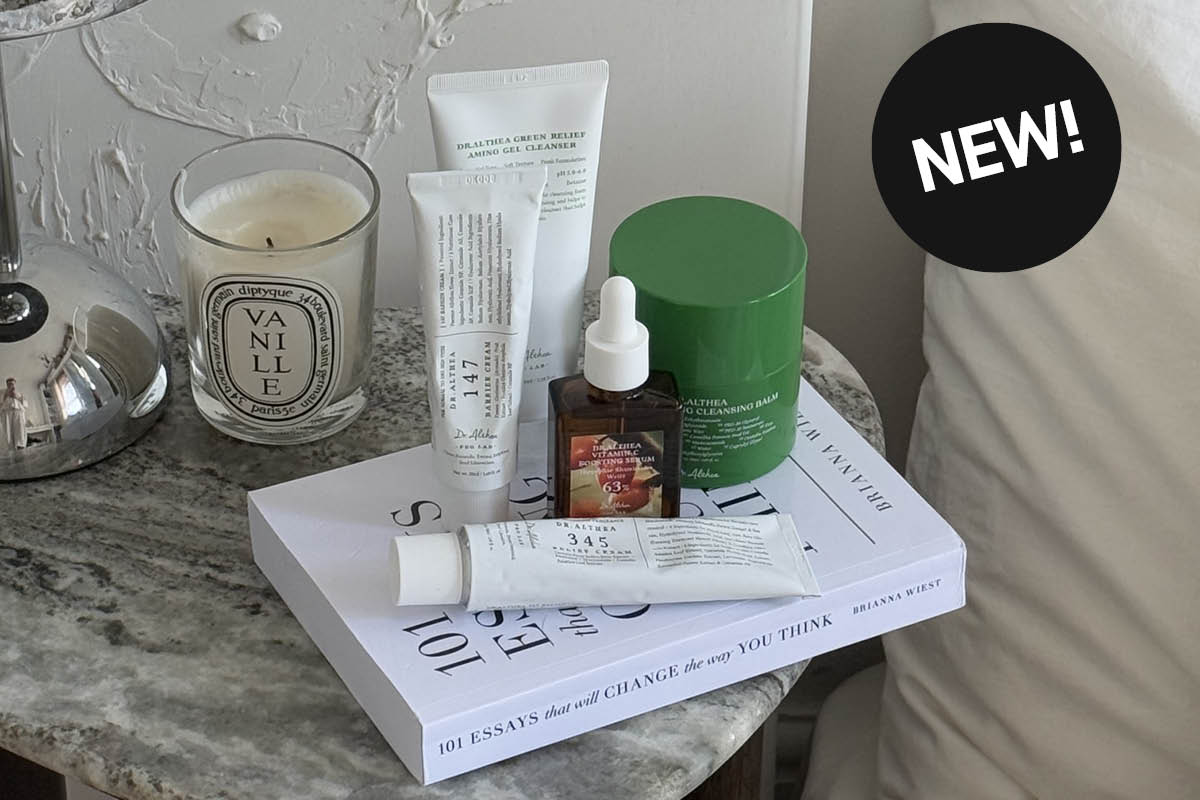 Dr. Althea hudvårdsprodukter på bord bredvid bok och ljus.