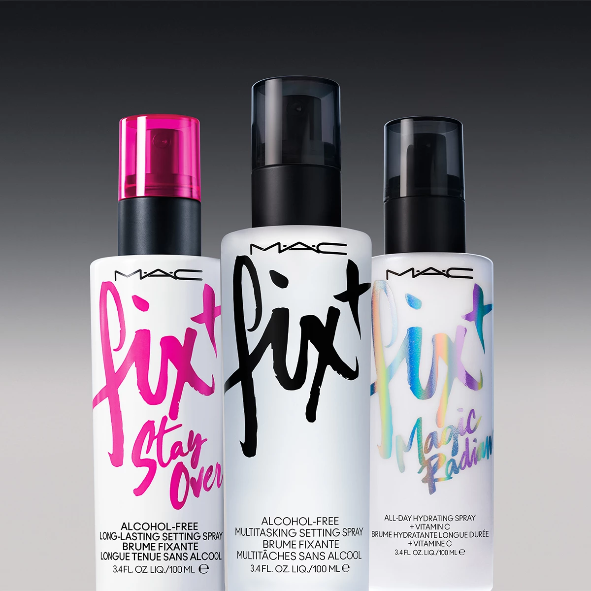 Tre forskjellige settingsprayer fra MAC Cosmetics er stilt opp mot en mørkegrå bakgrunn. Alle flaskene har hvit emballasje med tekst på.