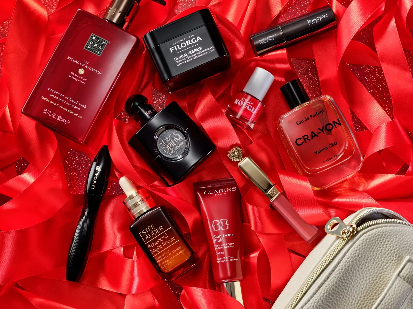 Yksitoista kauneustuotetta eri merkeiltä, levitetty punaisten nauhojen kanssa punakimaltelevalle taustalle.