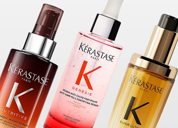 Produktbild med tre hårvårdsprodukter från Kérastase. Tre genomskinliga flaskor med pump i bruna, rosa och gyllene nyanser, placerade bredvid varandra mot ljus bakgrund.